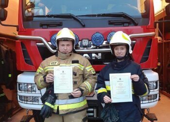 Kobieta za kierownicą wozu strażackiego.